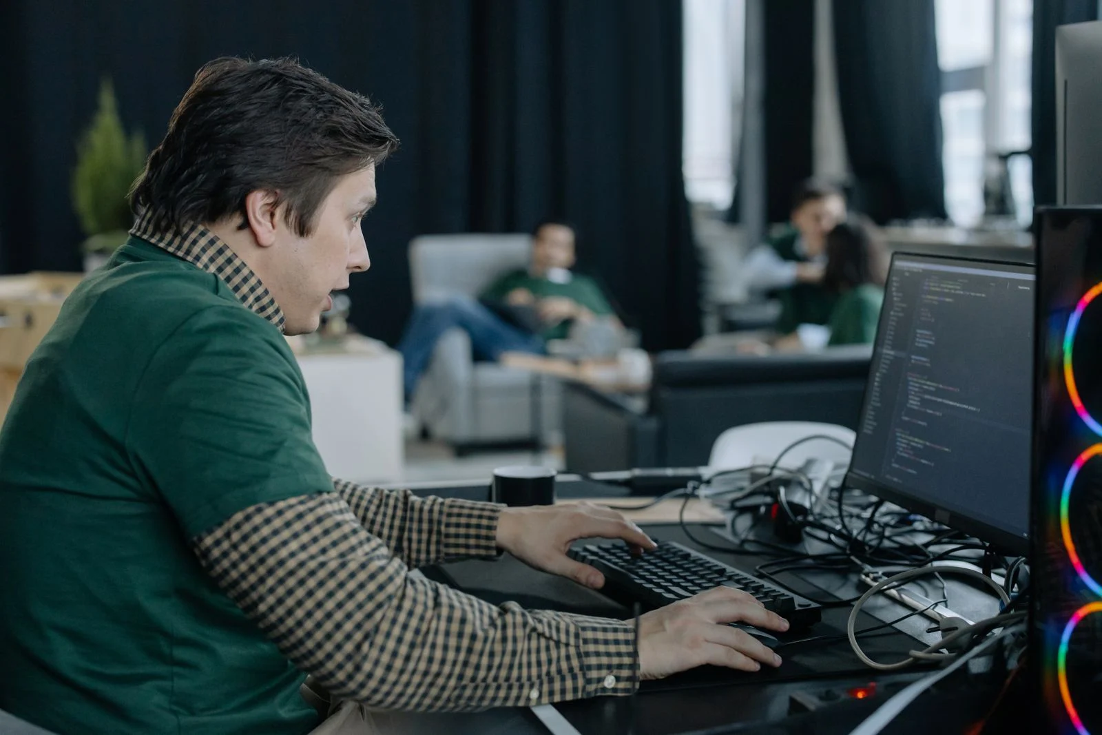 Software developer working at a desktop computer in an office.
